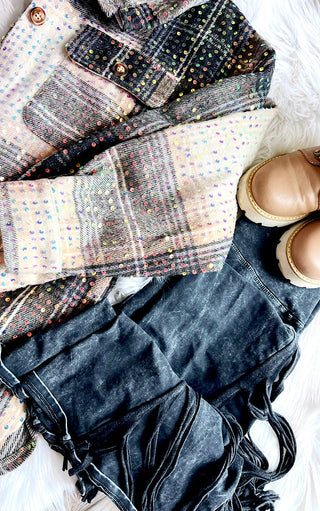 Flat lay of Plaid sequin shacket with button front, chest pockets, dark jeans and tan boots