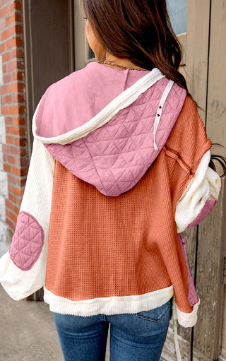 Back view of woman wearing the Charleston Charm Jacket in apricot and ivory waffle knit with pink quilted contrast hood, styled with jeans.