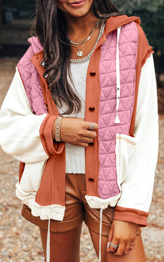 Close up view of Woman wearing the Charleston Charm Jacket in apricot and ivory waffle knit with pink quilted contrast, styled with brown shorts and layered necklaces.