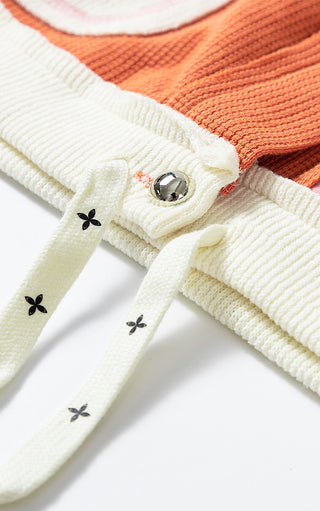 Close up view of hemline 9f Charleston Charm jacket showing ivory and orange waffle knit and drawstring waist