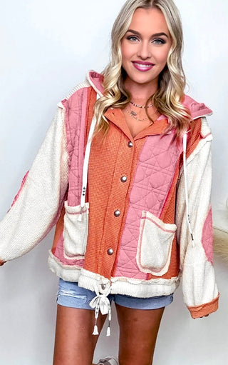 Woman wearing the Charleston Charm Jacket in apricot and ivory waffle knit with pink quilted contrast, styled with denim shorts and layered necklaces.
