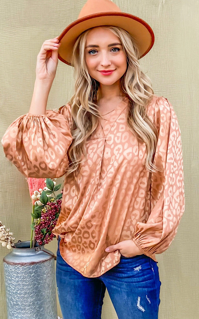 Silky bronze animal print top on blonde female wearing a hat and jeans