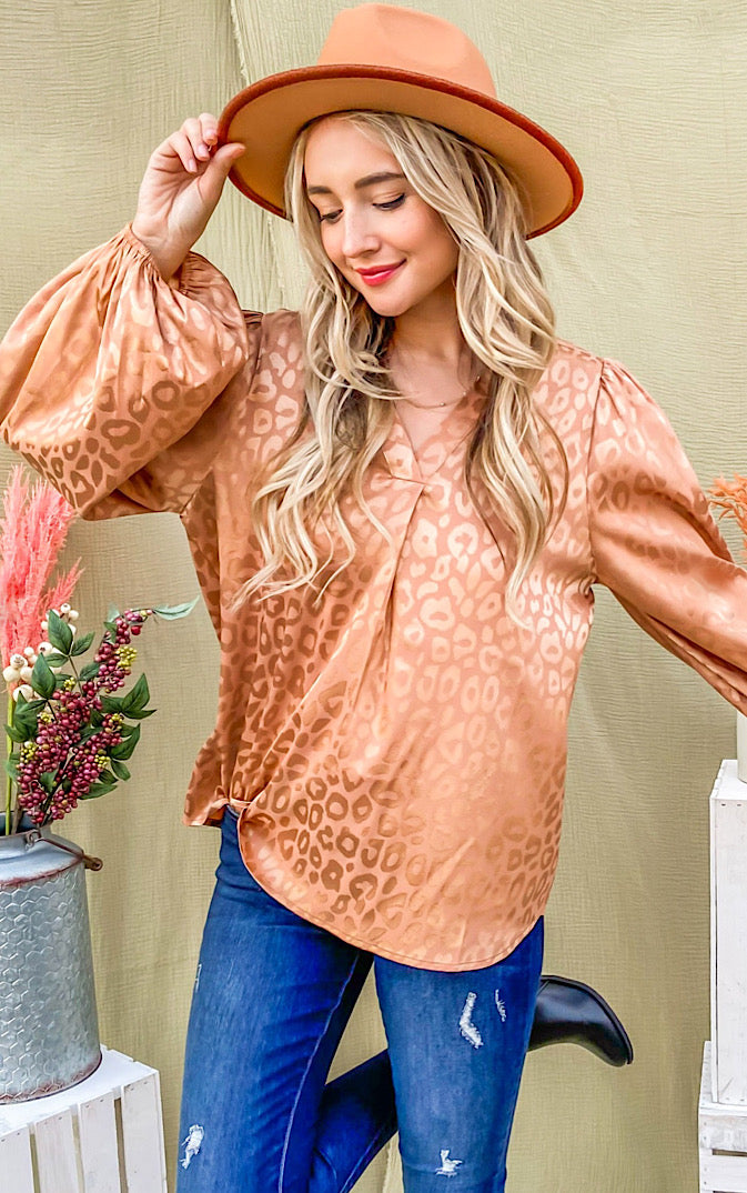 Silky bronze animal print top on blonde female wearing a hat and jeans