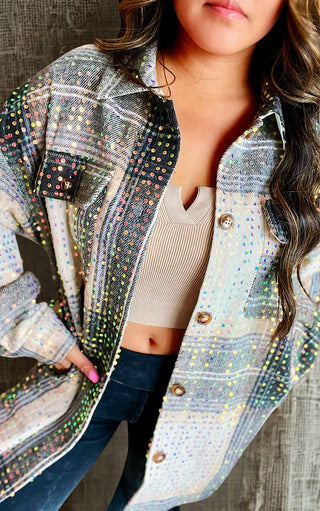 Close up of plaid sequin shacket with button front, chest pockets, and relaxed fit  styled with dark jeans.