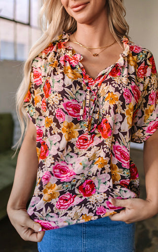 Woman wearing a colorful floral blouse with a blurred background