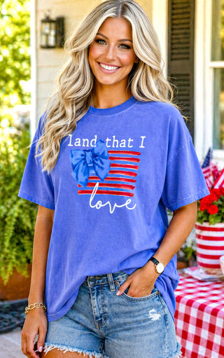 Woman wearing a blue t-shirt with a patriotic design, standing outdoors.