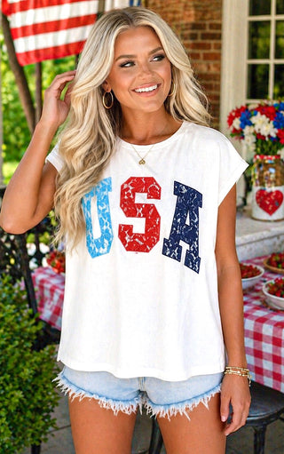 Woman wearing a white t-shirt with 'USA' print outdoors