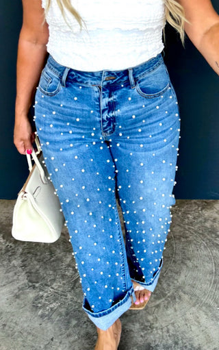 Close-up of Blakeley pearl-studded cropped jeans, cuffed straight leg denim with riveted pearl details.