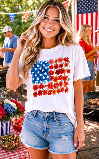 Woman wearing a white t-shirt with a colorful American flag design at a Memorial day event.