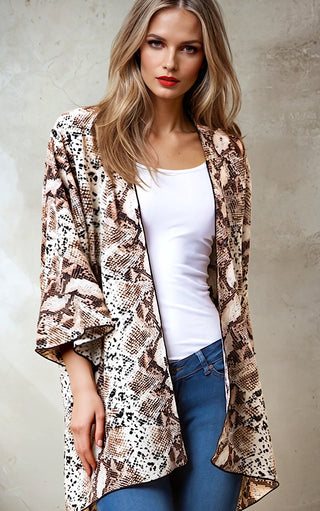 Model wearing a snakeskin print kimono cardigan over a white tank top with blue jeans.
