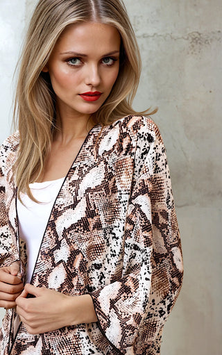 Woman wearing a snake print jacket against a neutral background