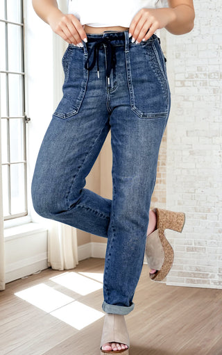 Person wearing blue jeans indoors with a neutral background
