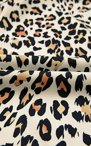 Fabric close-up of leopard print blouse, showing smooth lightweight texture and bold animal print pattern.