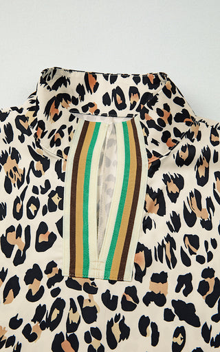 Close-up detail of striped trim split neckline on leopard print blouse, showing green, brown, and beige striped accents.