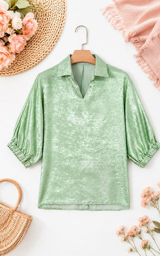 Green blouse on a hanger with flowers and a basket on a white background