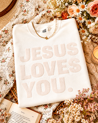 Ivory Jesus Loves You Comfort Colors graphic tee with textured lettering styled in an autumn flat lay