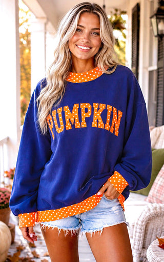  Woman wearing a navy blue pumpkin sweatshirt with orange polka dot appliqué for fall