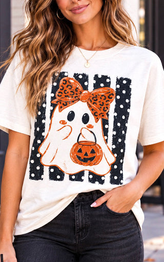 A woman wearing a white graphic t-shirt with a polka dot Halloween ghost design, paired with black jeans.