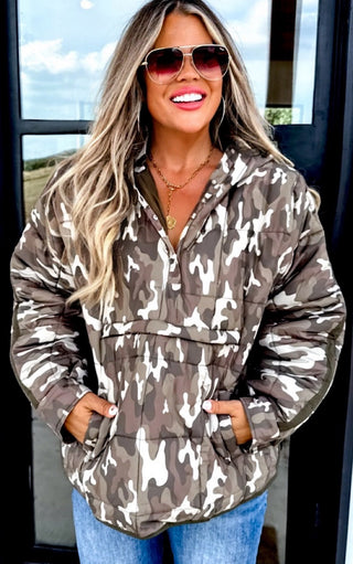 Woman wearing a camouflage jacket with a neutral background