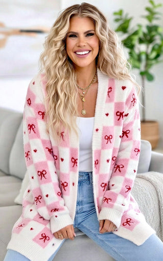 Woman wearing a white cardigan with red bows in a living room setting