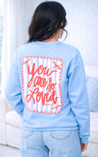 Light blue sweatshirt with 'You are so loved' text on the back, worn by a person.