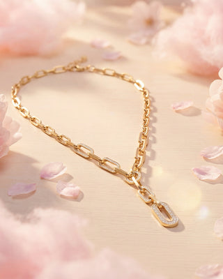 Gold bracelet with diamond accents on a soft pink floral background