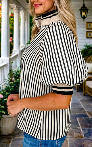 Side view of Black and tan striped puff sleeve blouse with zip neckline women’s boutique fashion top styled with jeans