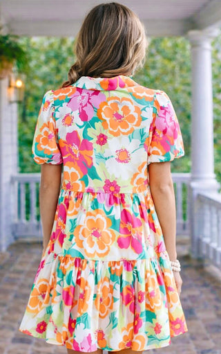 back view of Woman wearing a colorful floral dress on a porch