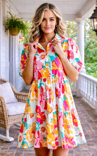Woman wearing a colorful floral dress on a porch