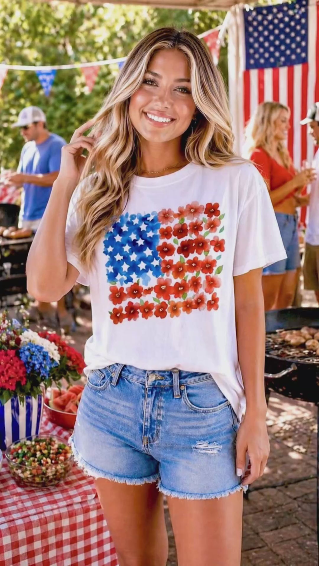Video of a Woman wearing a white t-shirt with a colorful American flag design at a casual outdoor cookout
