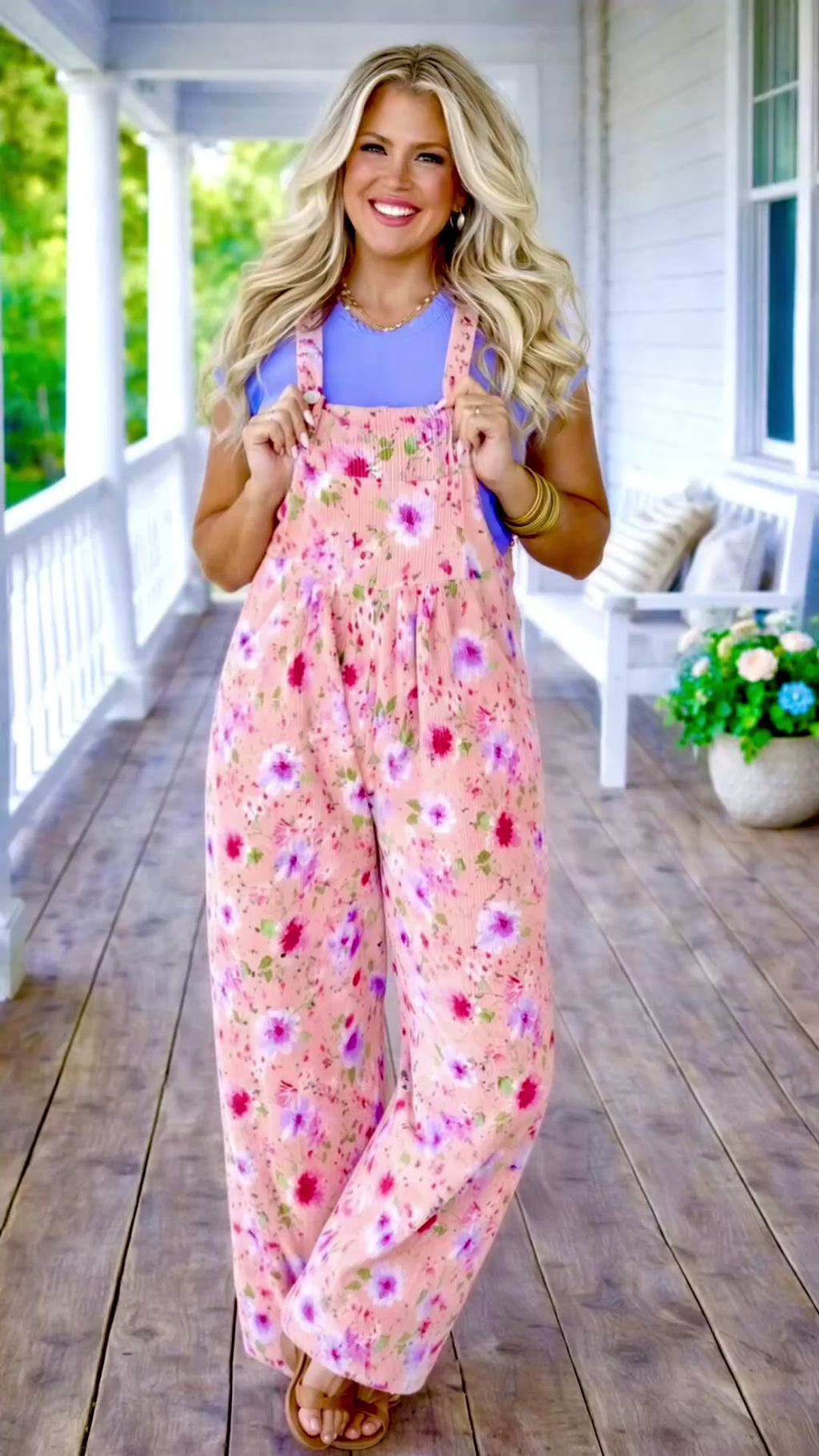 Video of Blonde model wearing pink floral ribbed overalls with a lavender tee on a spring southern front porch 