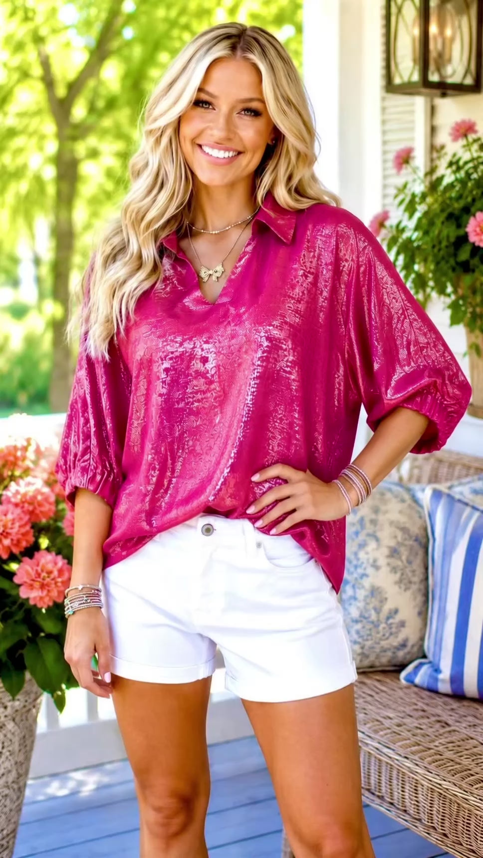 Video of blonde model wearing hot pink shiny shirt with white shorts.