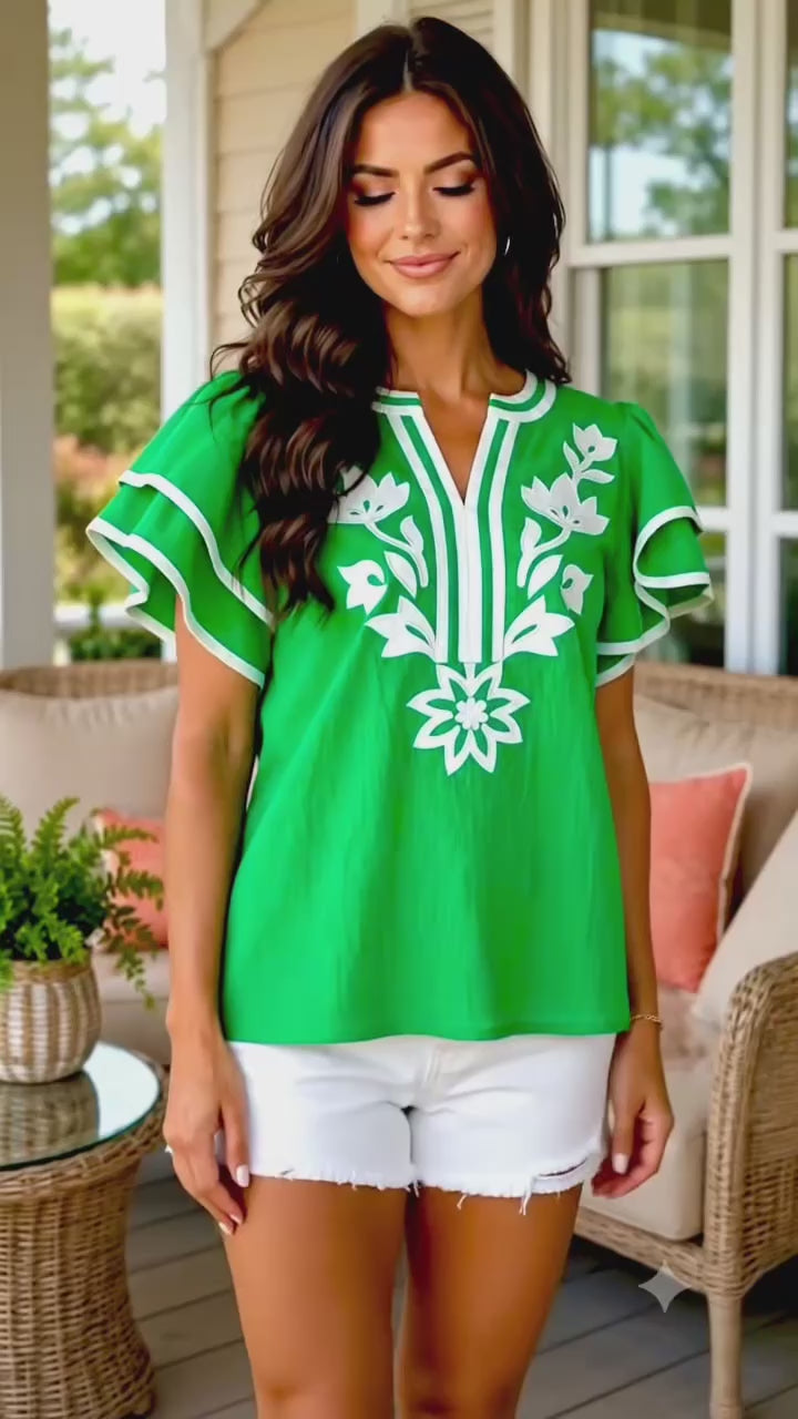 Video of beautiful brunette model wearing green embroidered top.
