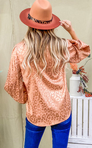 Silky bronze animal print top on blonde female wearing a hat and jeans