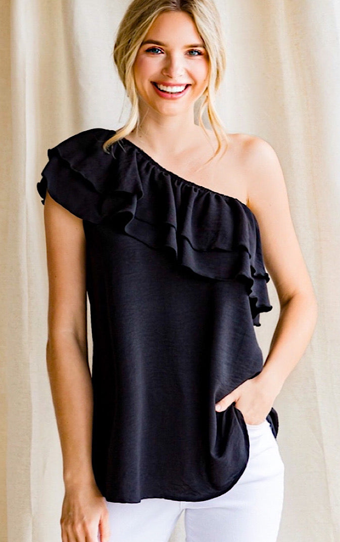 Black one shoulder top with ruffles on a blonde girl with ponytail.