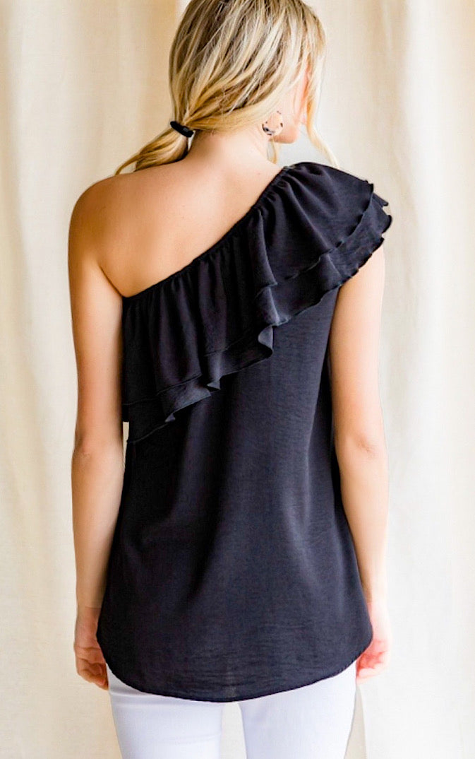 Black one shoulder top on a blonde haired girl with ponytail. View of back.
