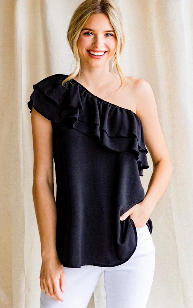 Black one shoulder top with ruffles on a blonde haired girl with ponytail.